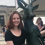 Portrait of Megan D hugging a deer statue.